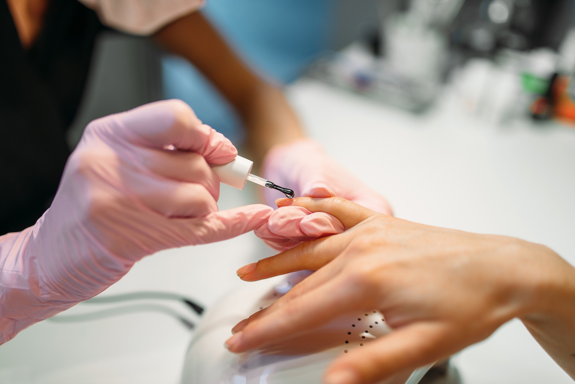 beautician-applying-nail-varnish-to-female-client-2023-11-27-05-14-34-utc.jpg