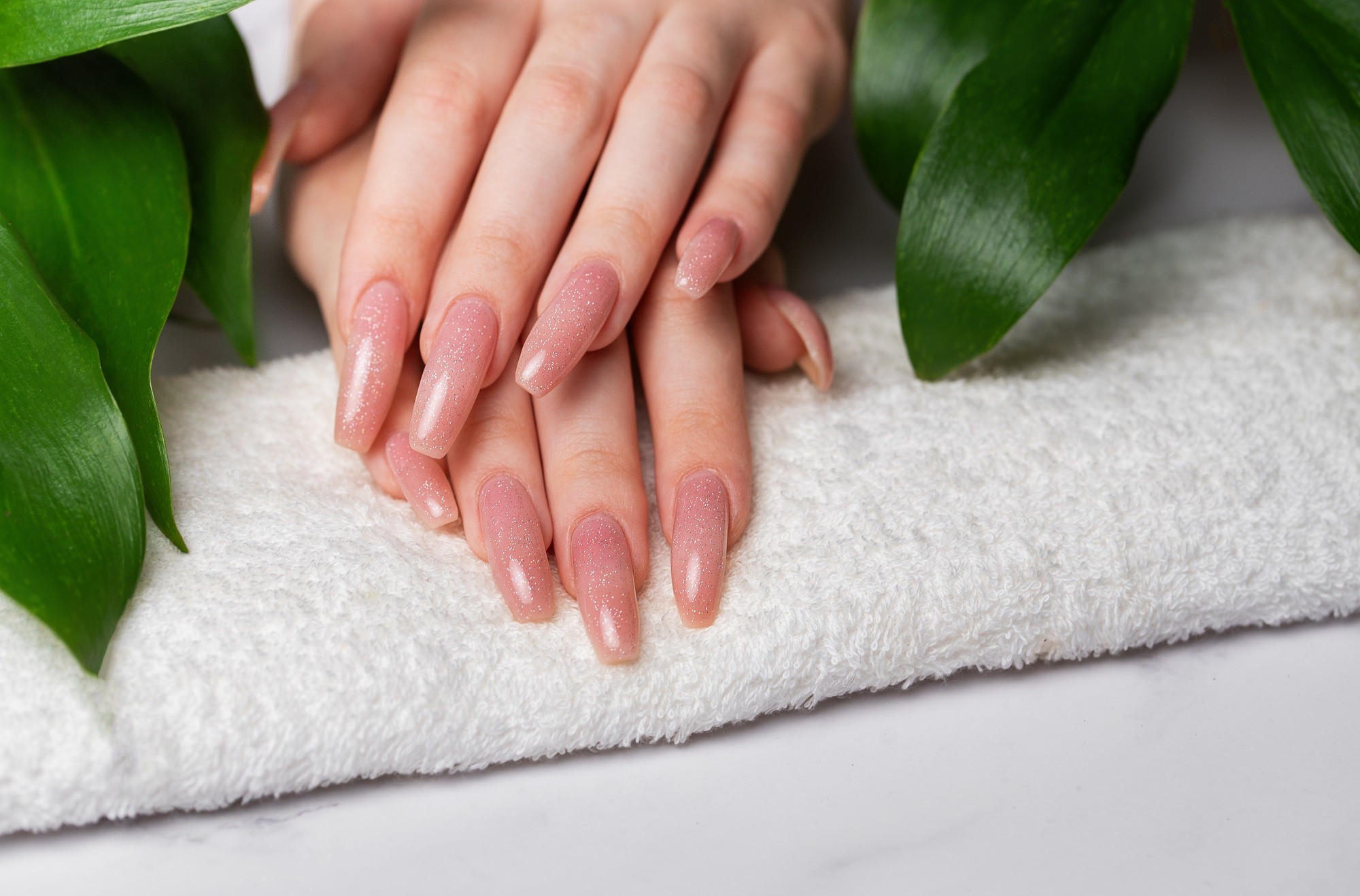 female-hands-with-pink-nail-design-and-green-lea-2023-12-18-23-05-48-utc.jpg